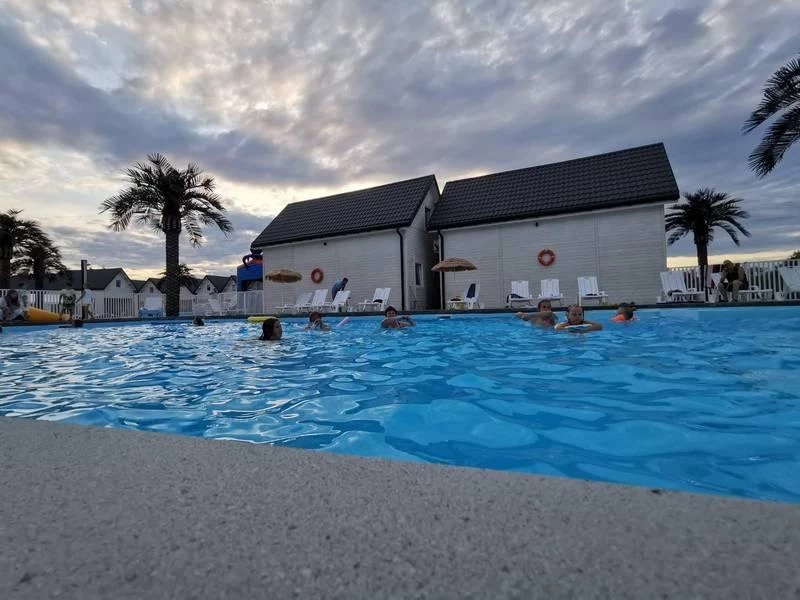 Basen na terenie ośrodka o zachodzie słońca